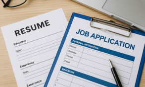 Professional resume and job application form on a desk with laptop, pen, and glasses, representing employment support services in Hanford, Visalia, and Lemoore.